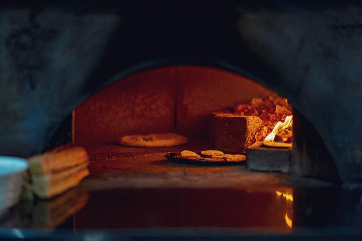Loaves and pizza bases resting on a wooden tray